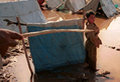 child standing in Jalozai camp after a downpour, awash with water and sewage